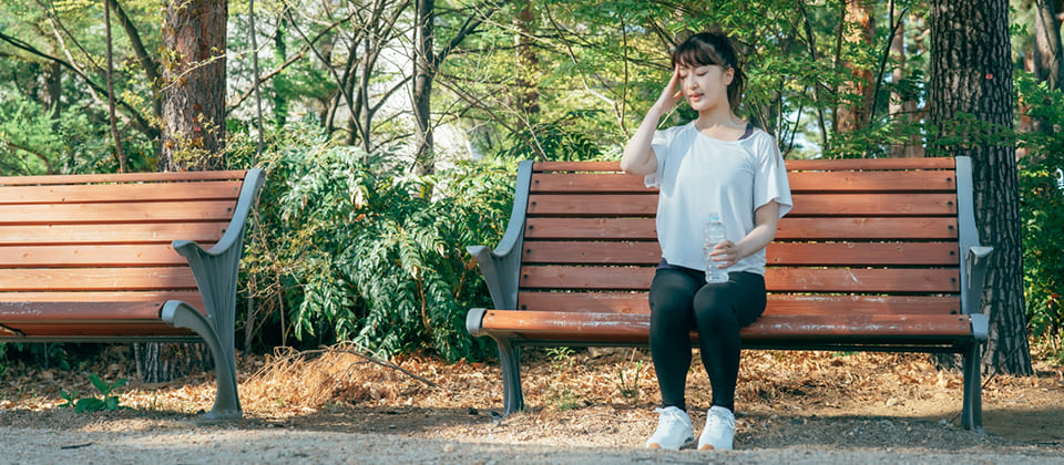 貧血でベンチで休む女性